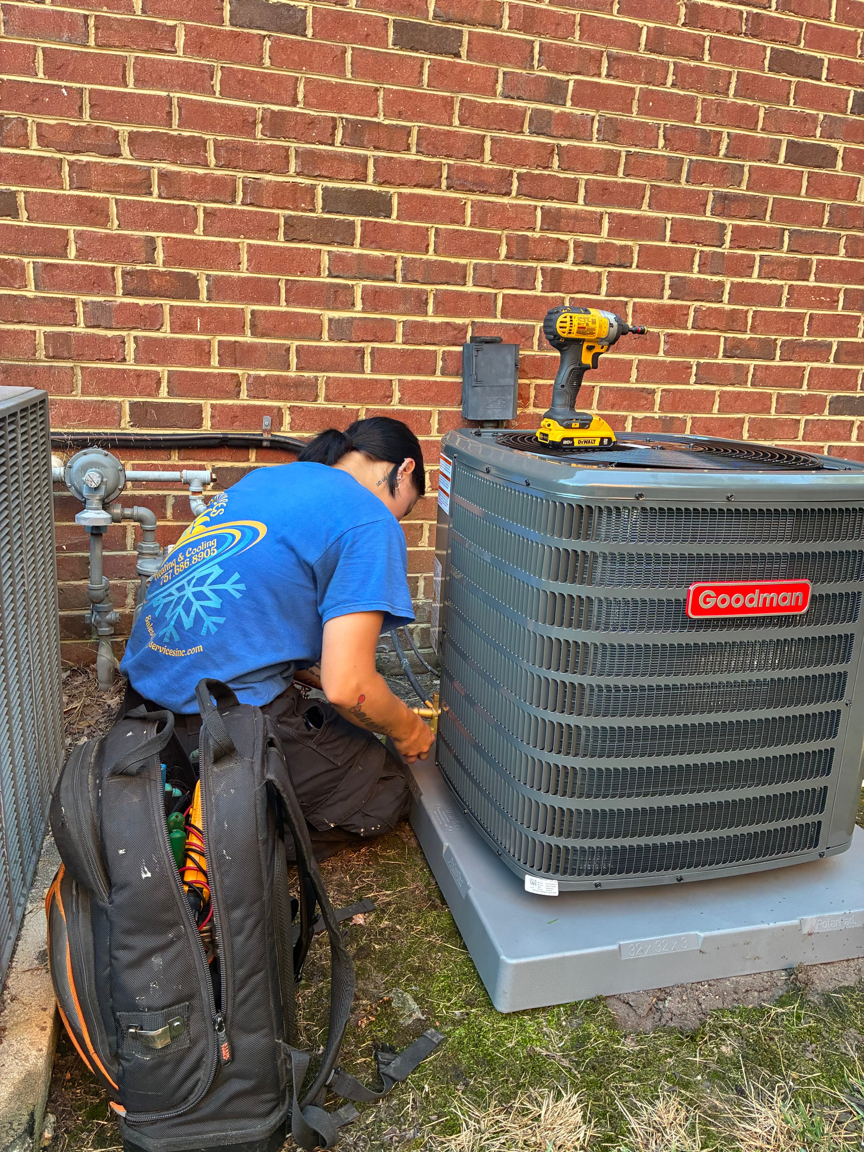 M&J Services technician servicing a Goodman AC unit